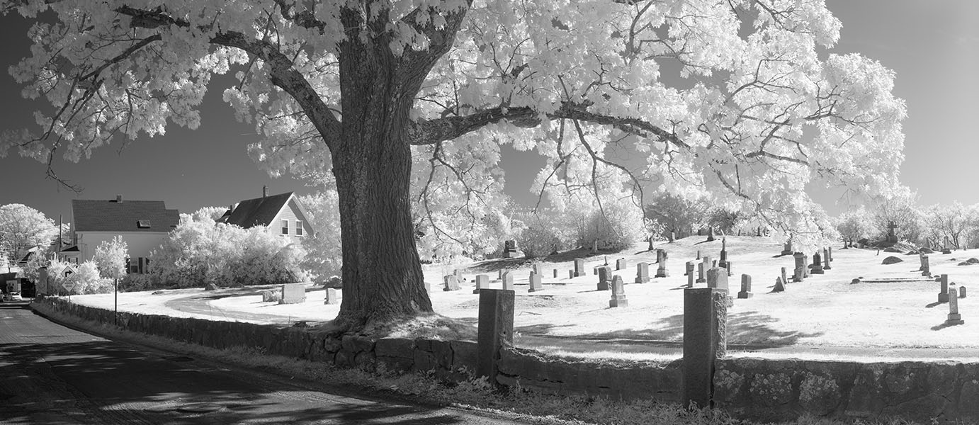 Infrared Panoramic Photo of a New England Cemetary Behing a Stone Wall.